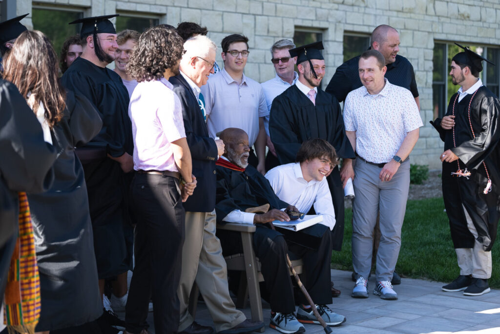 Rev. Dr. Robert L. Polk chats and poses for photos with members of all ages in Doane University’s Delta Kappa Pi fraternity, affectionately known as the “Dekes.” Polk, Doane’s first Black graduate in 1952, was active in the fraternity during his years on campus.